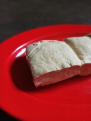Raw tofu on a red plate.
