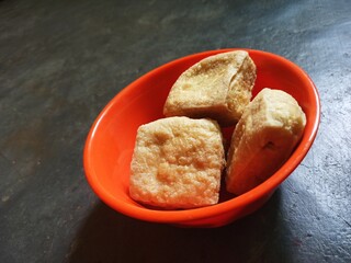 Fried tofu in a bowl, isolated with ash