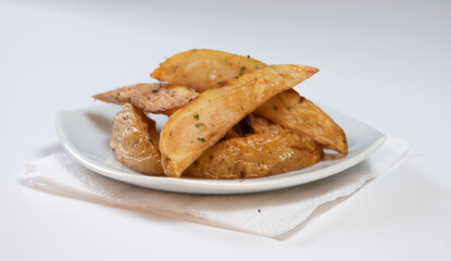 Rustic or Country Style Herb Fries potatoes on a Small Plate on a White Surface or background