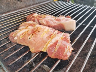 Fresh grilled pork placed on a metal rack.