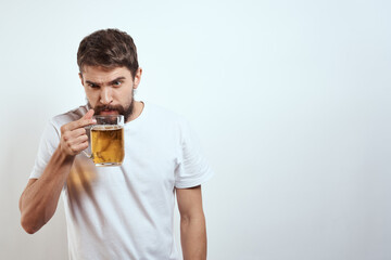 man with a mug of beer in his hands and a white t-shirt light background mustache beard emotions model