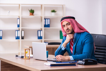 Fototapeta na wymiar Young male arab employee working in office