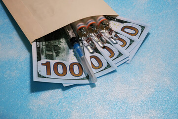 dollars in an envelope with ampoules and the syringe, as the concept of assignment for medicine,...