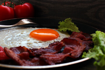Fried eggs, omelet traditional rustic breakfast, fried eggs, roasted bacon, sausage for breakfast .  Healthy food