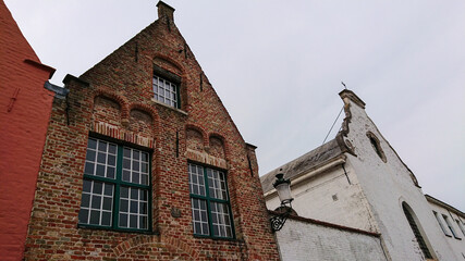 Roofs And Windows Of Old Authentic Brick Houses And Church In Bruges, Belgium