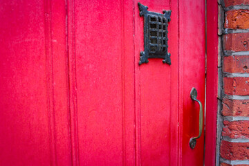 Red old wooden doors in a brick house