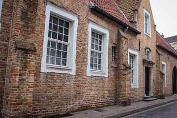 Roofs And Windows Of Old Authentic Brick Houses And Church In Bruges, Belgium.