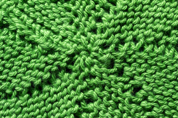 Full frame macro art abstract view of a green crocheted yarn doily texture on a dark blue background, with copy space.