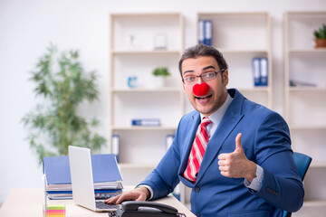 Funny employee clown working in the office