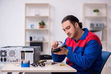 Young male repairman repairing computer