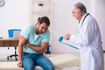 Injured young man visiting old doctor