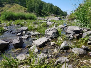 Stone boulders lie in a mountain river