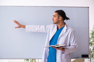 Young male doctor in presentation concept