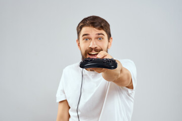 A man with a joystick in his hands fun games lifestyle white t-shirt light background