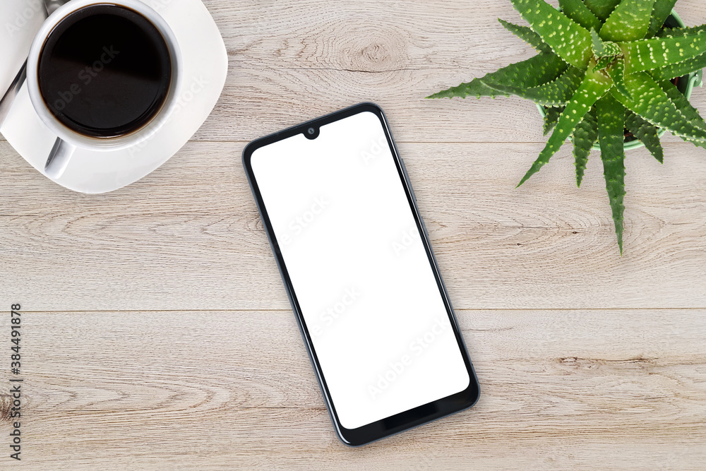 Wall mural top view of a new modern smartphone mockup with blank white screen on a wooden table with coffee and