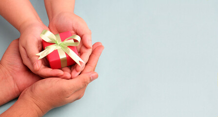 hands holding gift box on blue background With copy space.