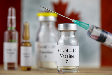 Canada Flag and bottle with vaccine and syringe, Coronavirus, Covid-19, Medicine, science and healthcare concept
