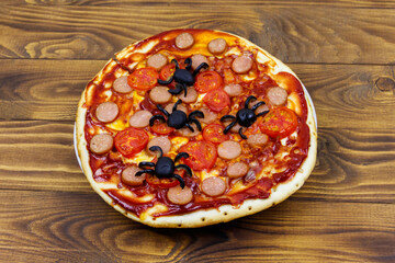 Halloween pizza with spiders on wooden table