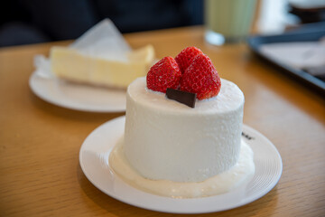 
White mini-cake with strawberries on it
