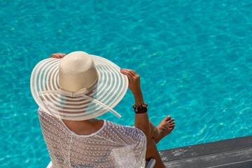 Fototapeta na wymiar woman at spa resort by the swimming pool.
