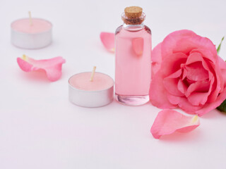 Obraz na płótnie Canvas Aromatherapy oil bottle and pink rose
