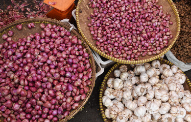 Red onions and garlic display in traditional market.