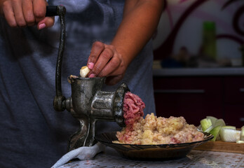 Cooking healthy minced meat,onions and spices in a meat grinder by hand.