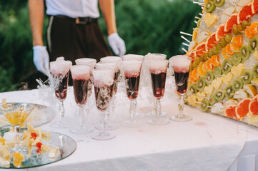 Alcoholic beverages in crystal glasses with dry ice and white smoke close up.