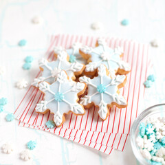 Multiple Snowflake Cookies on Candy Cane Stripe Paper with Blue and White Candy Snowflake Decorations
