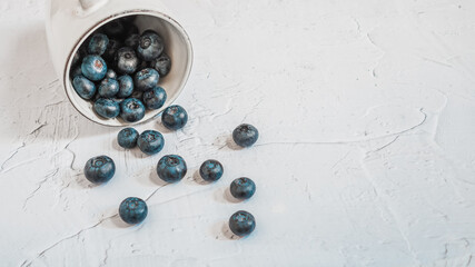 A glass full of blueberries in white & bright background