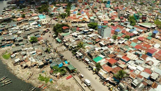 Slums with shacks of local residents and the river bank littered with garbage from above. Manila, Philippines.