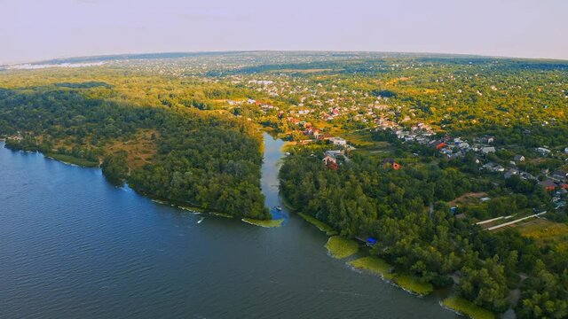 Aerial view over beautiful suburb with a wide river with  privat houses.  Top view over  a  people settlement near water.