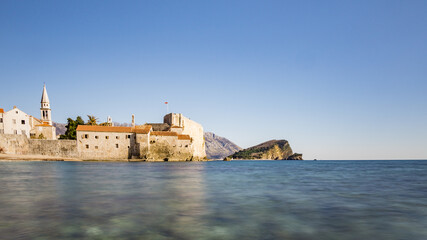 Strand mit himmel und Stadtmauer mit Burg und hafen von Budva in Montenegro