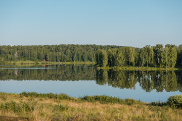 Lake in the forest. A beautiful reservoir. Wild nature. Sunny weather. The surface of the lake