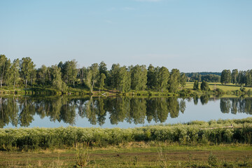 Lake in the forest. A beautiful reservoir. Wild nature. Sunny weather. The surface of the lake