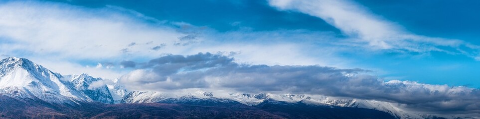 panoramic view of picturesque snowy mountains tops on blue sky background