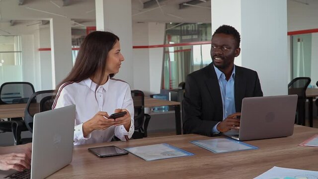 corporate business team employees sitting at the seak in open space room using devices slow motion panorama