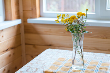 Flowers in a vase on the veranda. Yellow flowers. A bouquet of flowers on the table. Rural landscape. Romantic flowers in the house. Chrysanthemums in a vase.