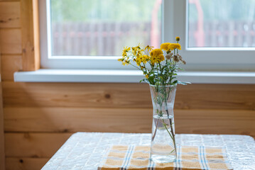 Flowers in a vase on the veranda. Yellow flowers. A bouquet of flowers on the table. Rural landscape. Romantic flowers in the house. Chrysanthemums in a vase.