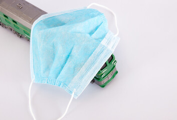 A green leather train and a disposable mask on a white background