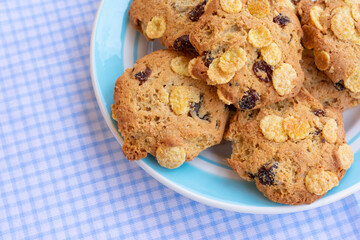 Group of cereal cookies in plate on table with tablecloth. Freshly baked oats biscuits.