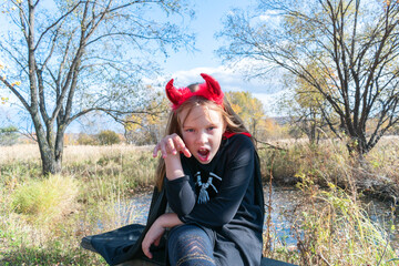 Child in a devil costume with horns.