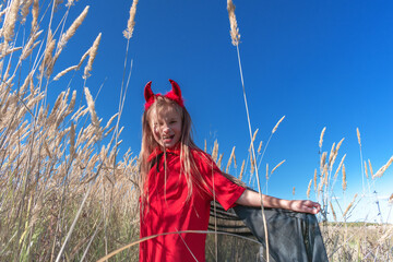 Child in a devil costume with horns.