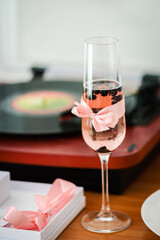 Champagne glass with berries inside and a gramophone on the background. Retro / vintage party concept.