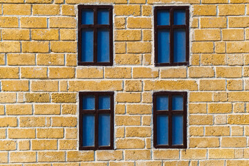 background from a miniature houses in a city park, yellow brick wall and windows