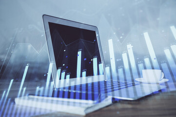 Stock market graph on background with desk and personal computer. Double exposure. Concept of financial analysis.