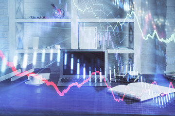 Stock market graph on background with desk and personal computer. Multi exposure. Concept of financial analysis.