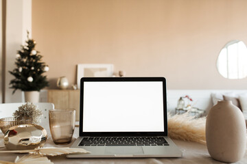 Blank display screen laptop computer on table with beautiful decorations. Modern cozy comfortable...