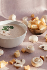creamy mushroom cream soup with champignons serving in delicate pink colors