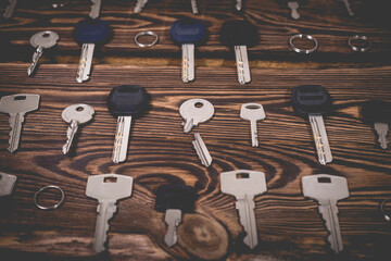 A studio photo of a broken key among many normal keys on a wooden background.